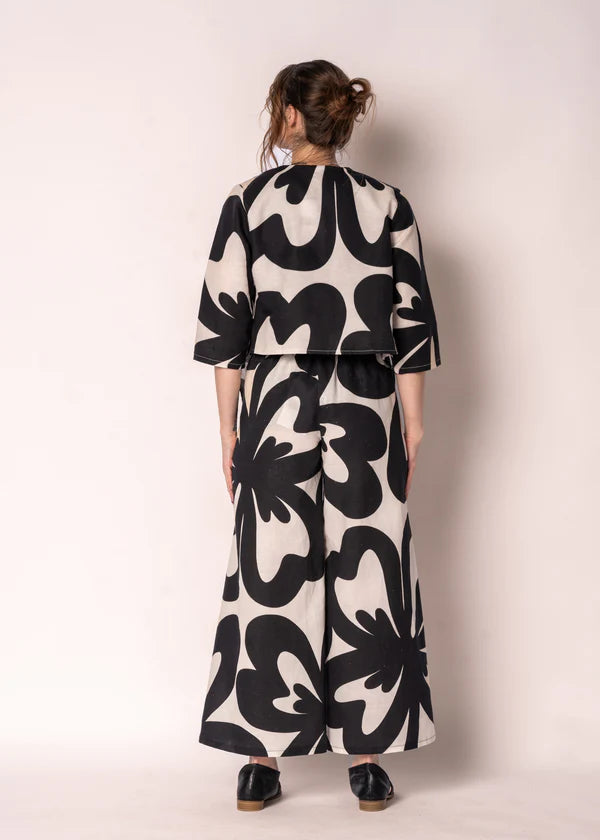 Cream linen-cotton straight-leg pants with black print, elasticated back waistband, flat front and side pockets