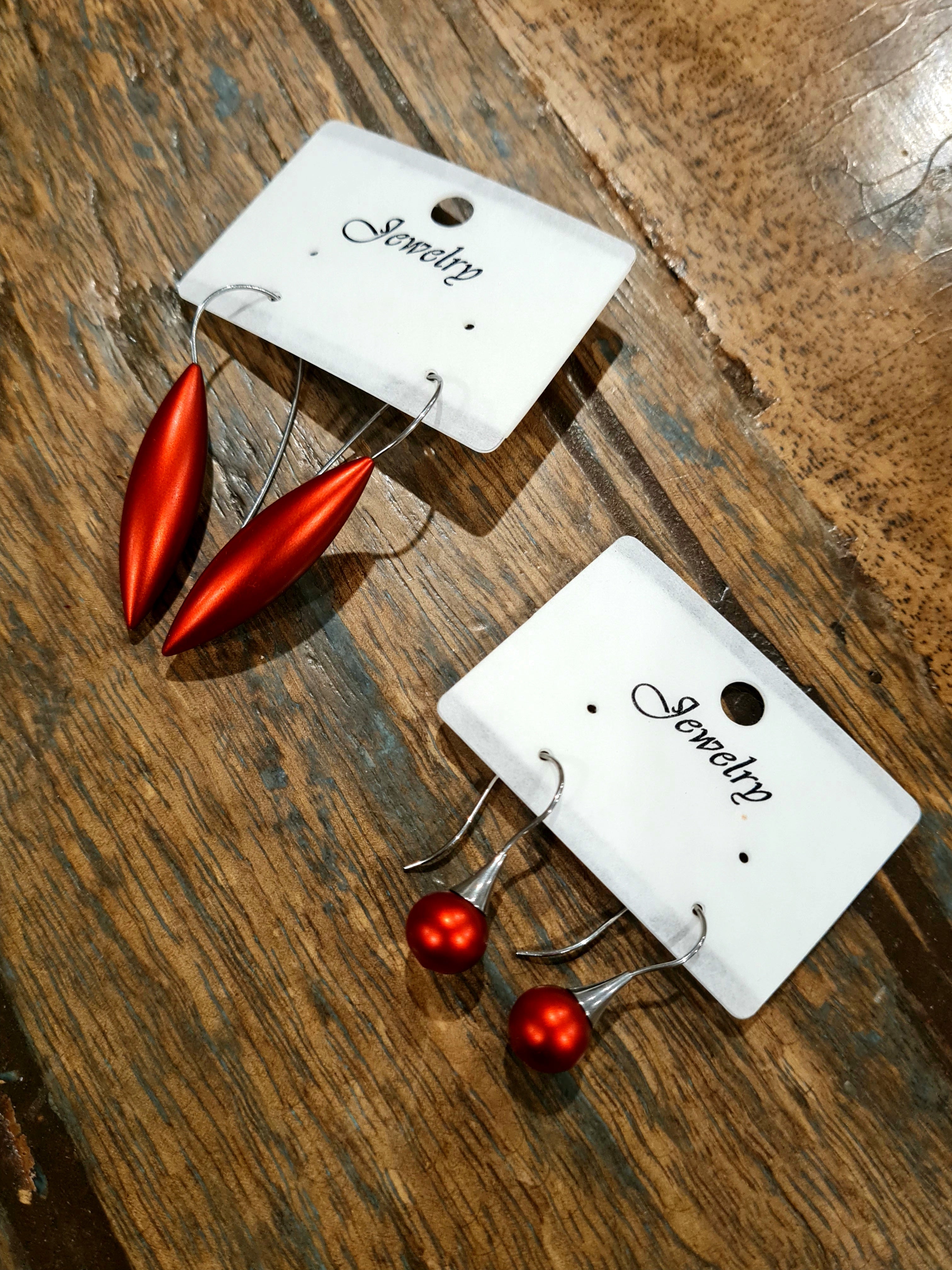 A curated selection of matte metal pieces in assorted colors, featuring two minimalist styles: elongated teardrop and droplet shapes, displayed side by side. Buy now at Linens & Treasures