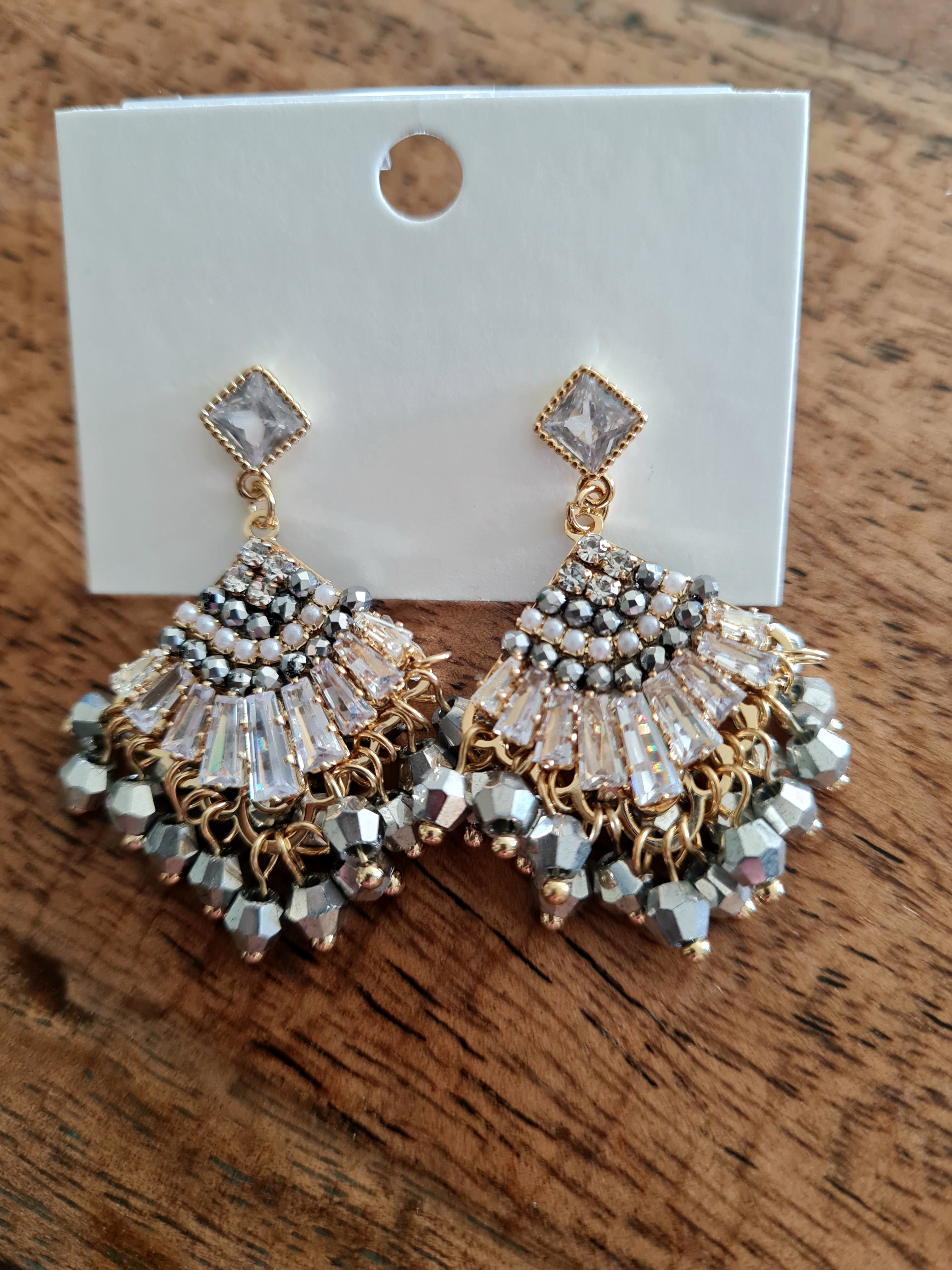 Fan-shaped earrings adorned with sparkling crystals and a few neutral-toned beads for a soft, elegant look. Buy now at Linens & Treasures