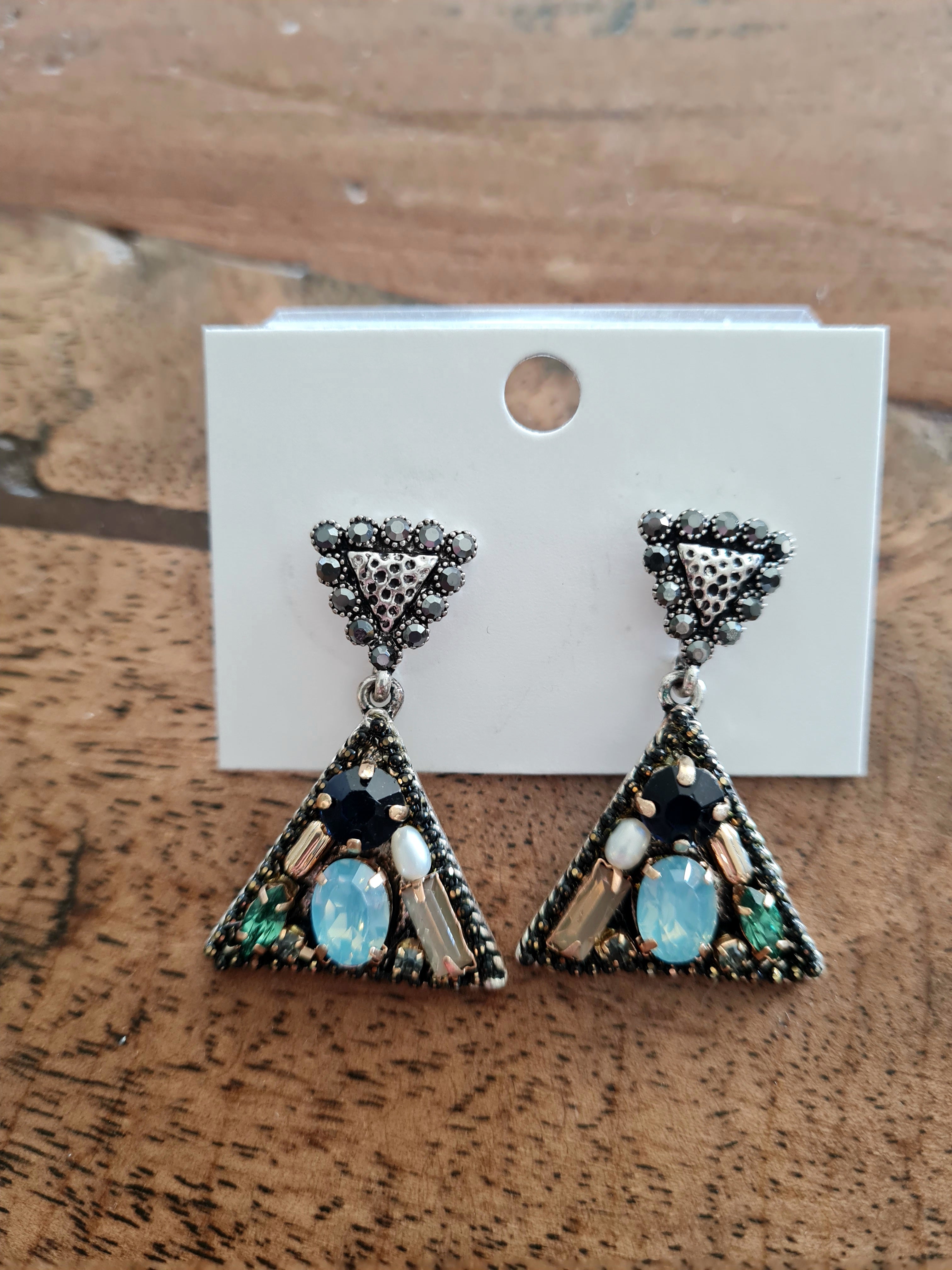 Handmade triangular earrings with teal and black crystals, finished with a marcasite-accented post. Don't miss these buy now at Linens & Treasures