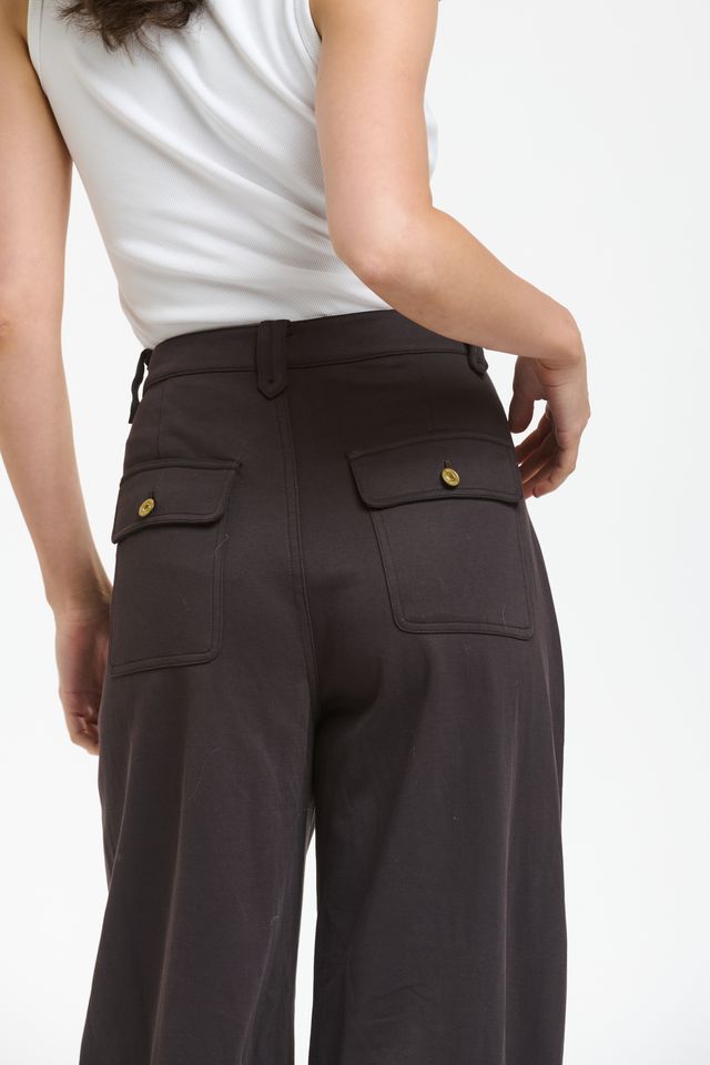 Italian Star PIMMS Pant in Morro, a rich chocolate plum shade, featuring a relaxed high-rise fit and on-trend wide-leg barrel silhouette. Made from a comfortable stretch cotton blend, these pants showcase a distinctive front pocket panel design, belt loops, zip fly, and cargo patch pockets at the back, creating a stylish yet casual aesthetic.