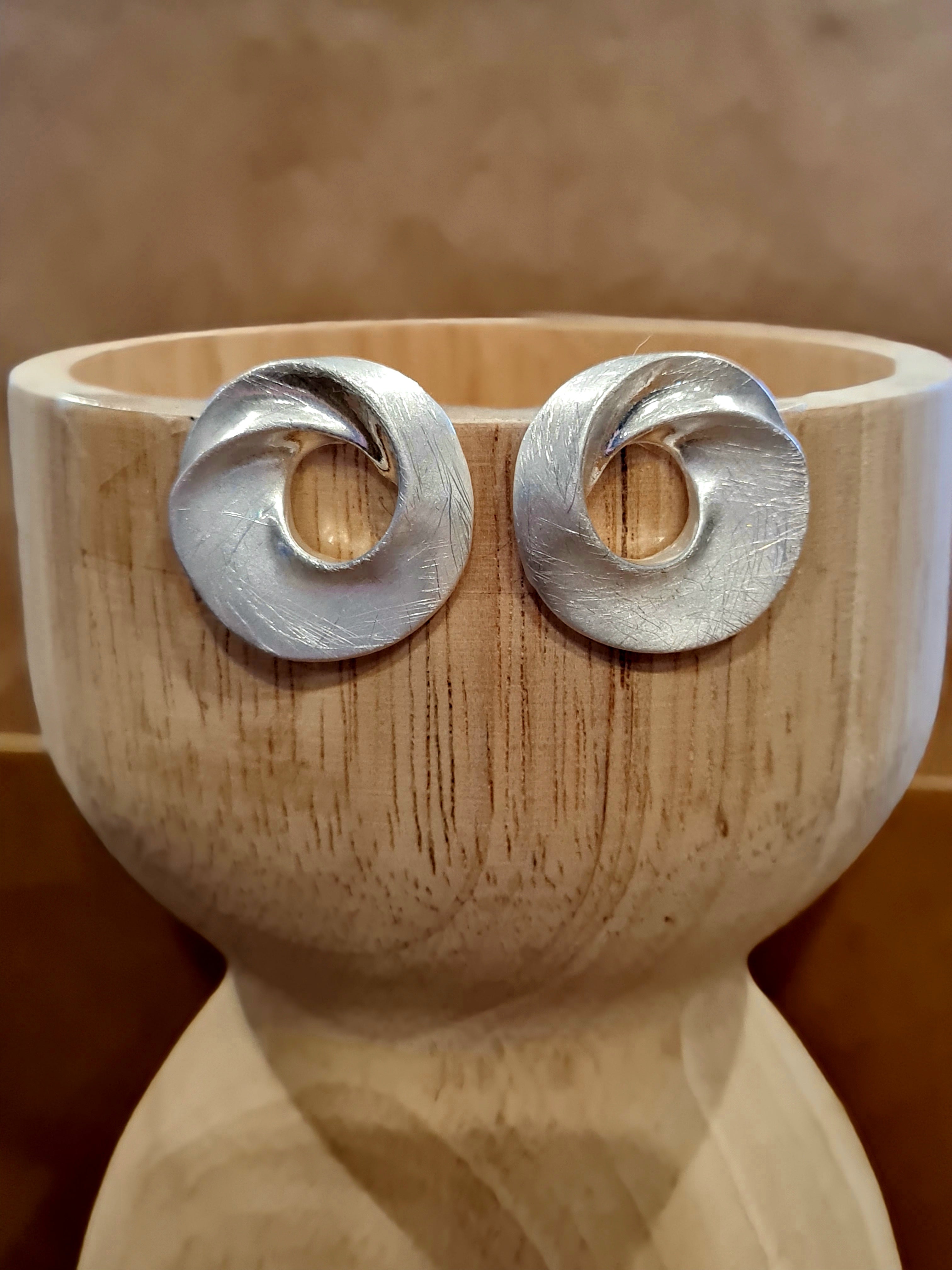 Modern circles in silver with a subtle scratched finish. A sleek, understated statement that pairs with everything. Check them out at Linens & Treasures