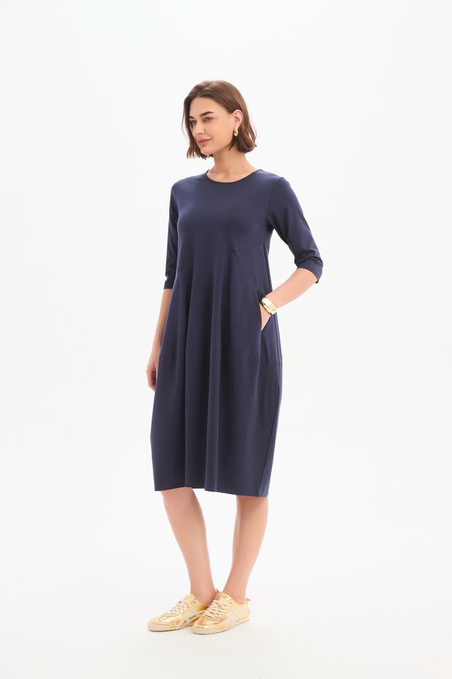 Tirelli Diagonal Seam Winter Dress in navy featuring a midi-length silhouette, diagonal seam detailing, rounded bubble hem, round neckline, and side pockets