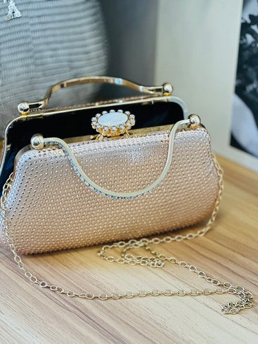 Champagne rhinestone evening clutch with gold-tone frame, top handles, statement clasp, and detachable chain strap.