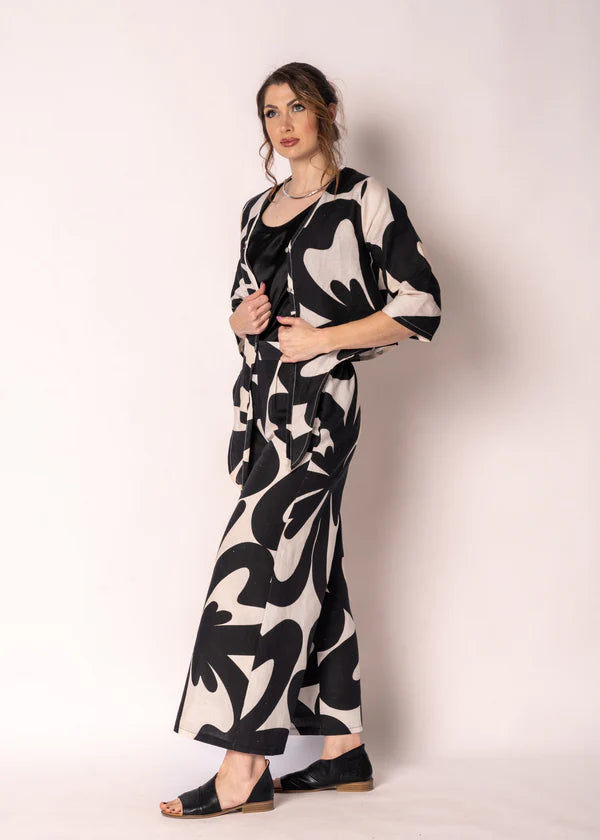 Cream linen-cotton straight-leg pants with black print, elasticated back waistband, flat front and side pockets