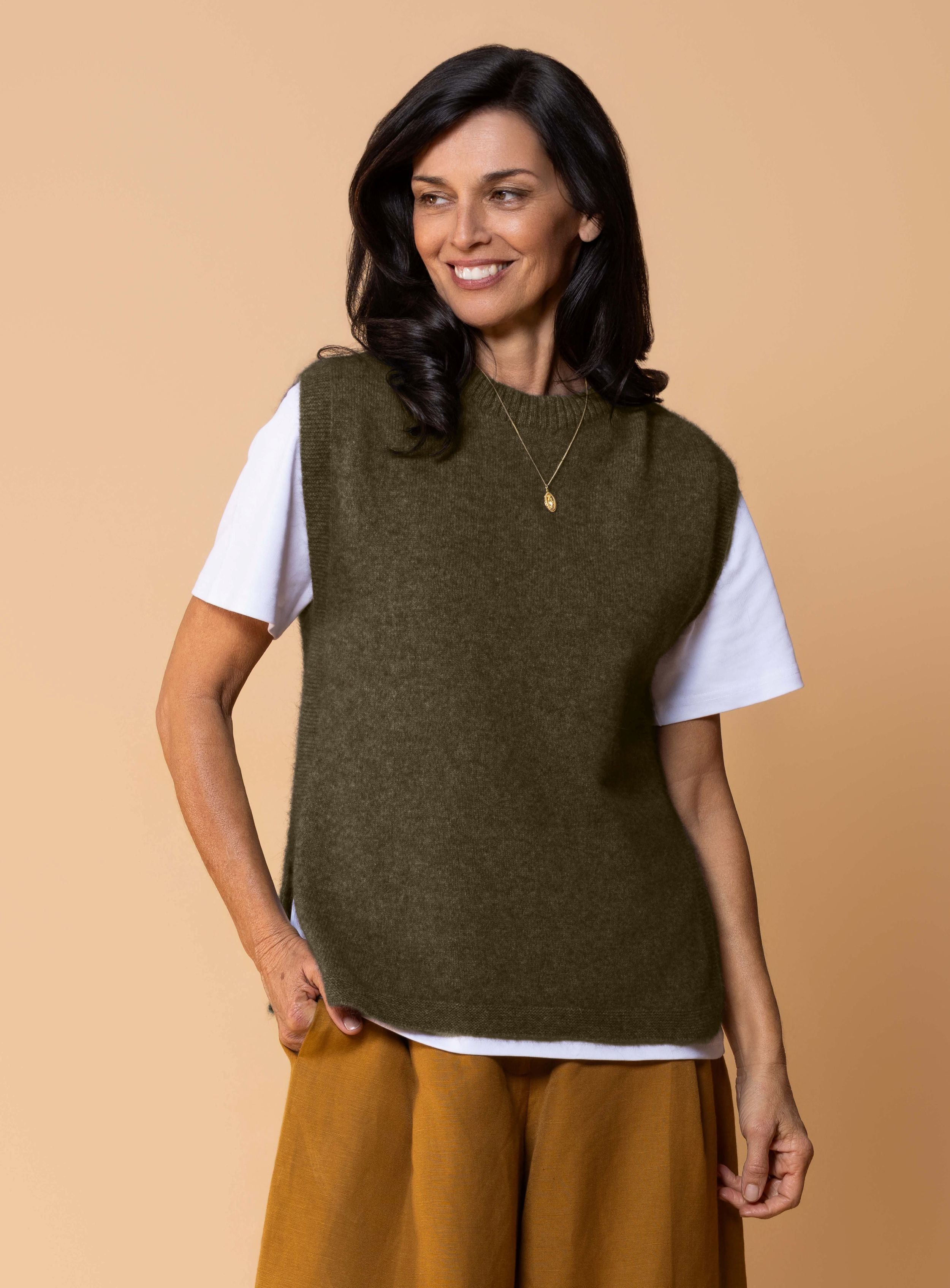 Women's Kowhai Vest in Avoka, rich avocado green possum merino knit sleeveless vest with round neckline, side splits and relaxed fit for layering.
