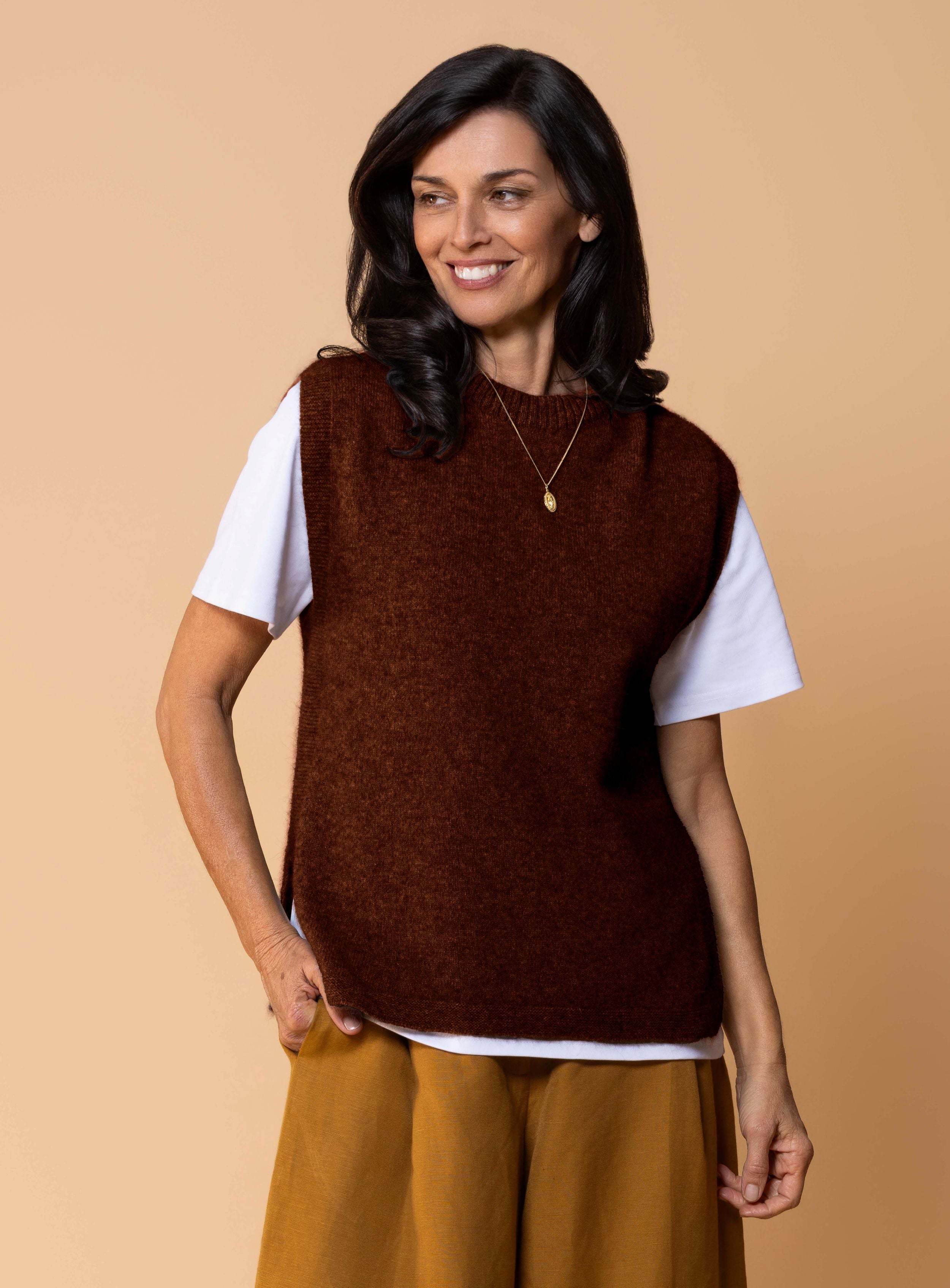 Women's Kowhai Vest in Rimu, earthy forest green possum merino knit sleeveless vest with round neckline, side splits and relaxed fit for layering.