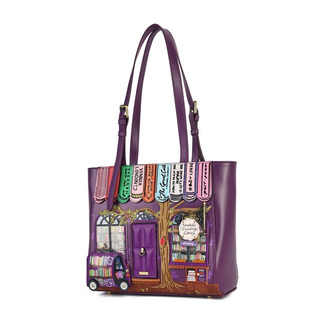 Vendula London The Travelling Library Bookshop Shopper Bag in printed and embossed vegan leather, featuring colourful bookshop and library artwork with bookshelves, paperbacks, shop signs, library windows and a travelling book van. Designed with hand-stitched details, two carry handles, a secure zip closure, one internal zipped pocket, two internal open pockets and an external zipped pocket.