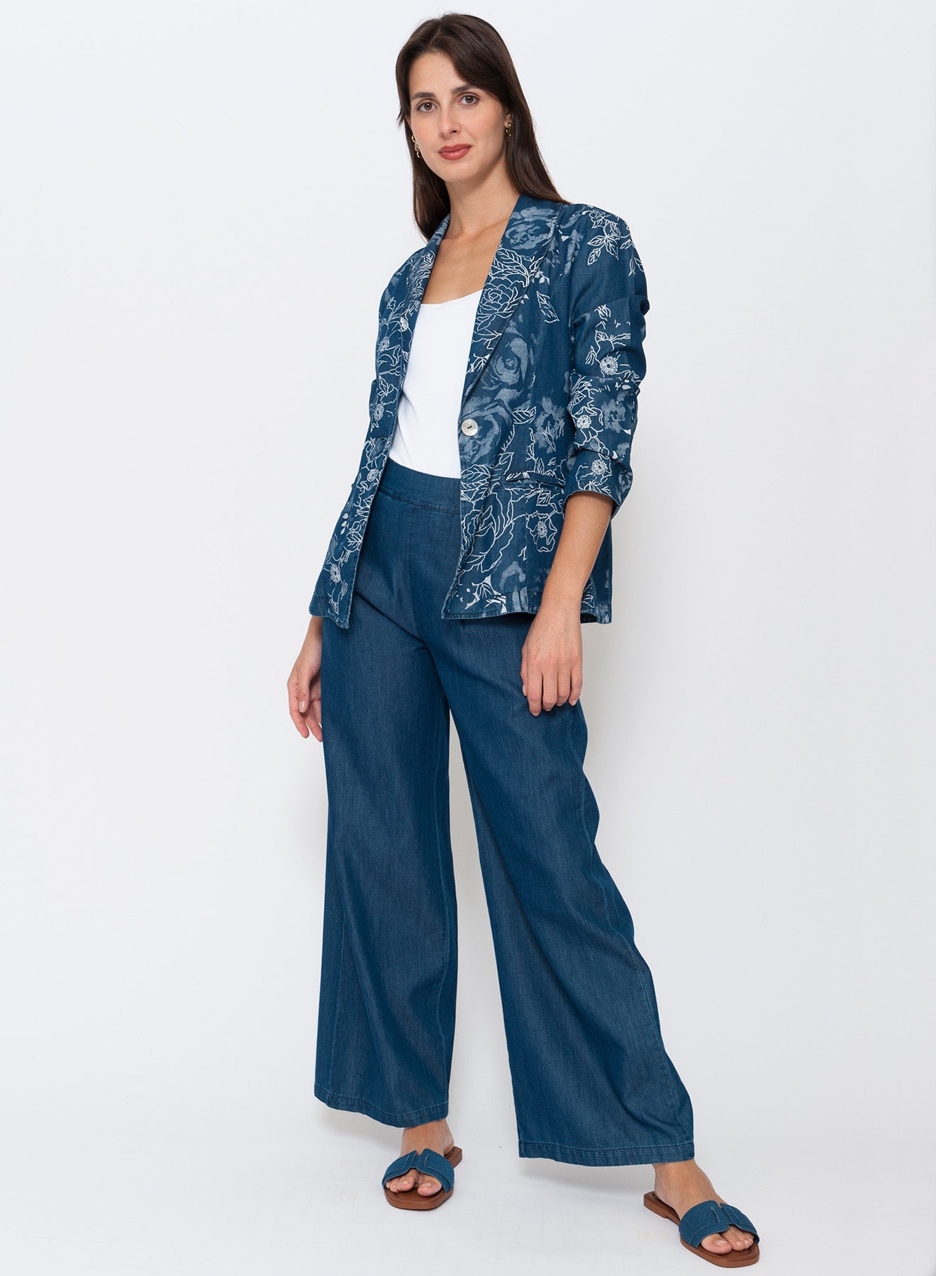Women’s tailored denim floral blazer made from a cotton and lyocell blend, featuring a lightly A-line silhouette, long lapel, single-button closure, and plaquette pockets. Available now at Linens & Treasures