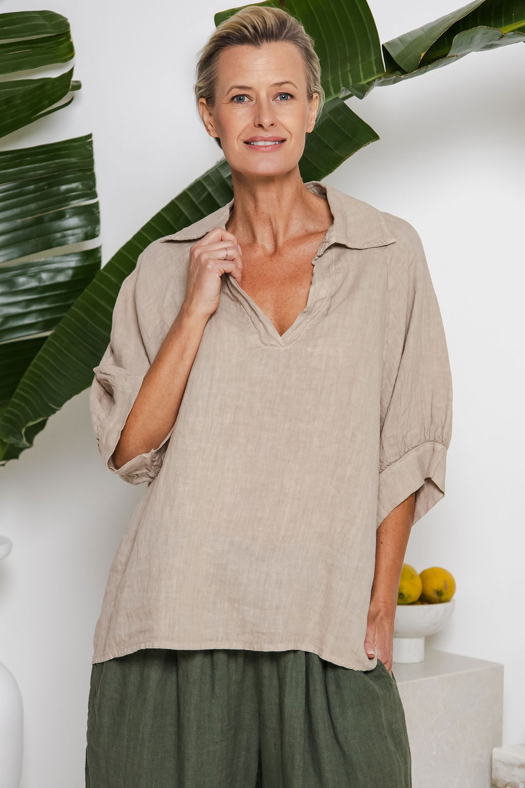 Neutral cashmere-tone linen top with collar, buttoned plaquette, and loose draped silhouette — eco-luxury design from Linens & Treasures