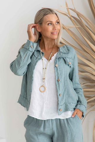 Tailored blue linen jacket with yoke, stitched panels, and buttoned waist tabs at Linens & Treasures