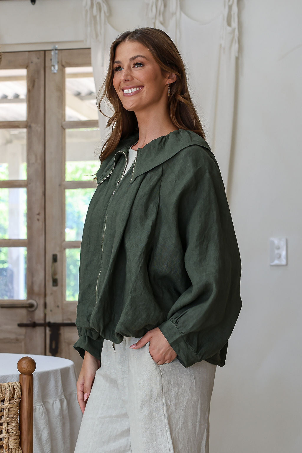 Juniper green linen bomber jacket with cape sleeves, zip front, wide collar and ruched waist