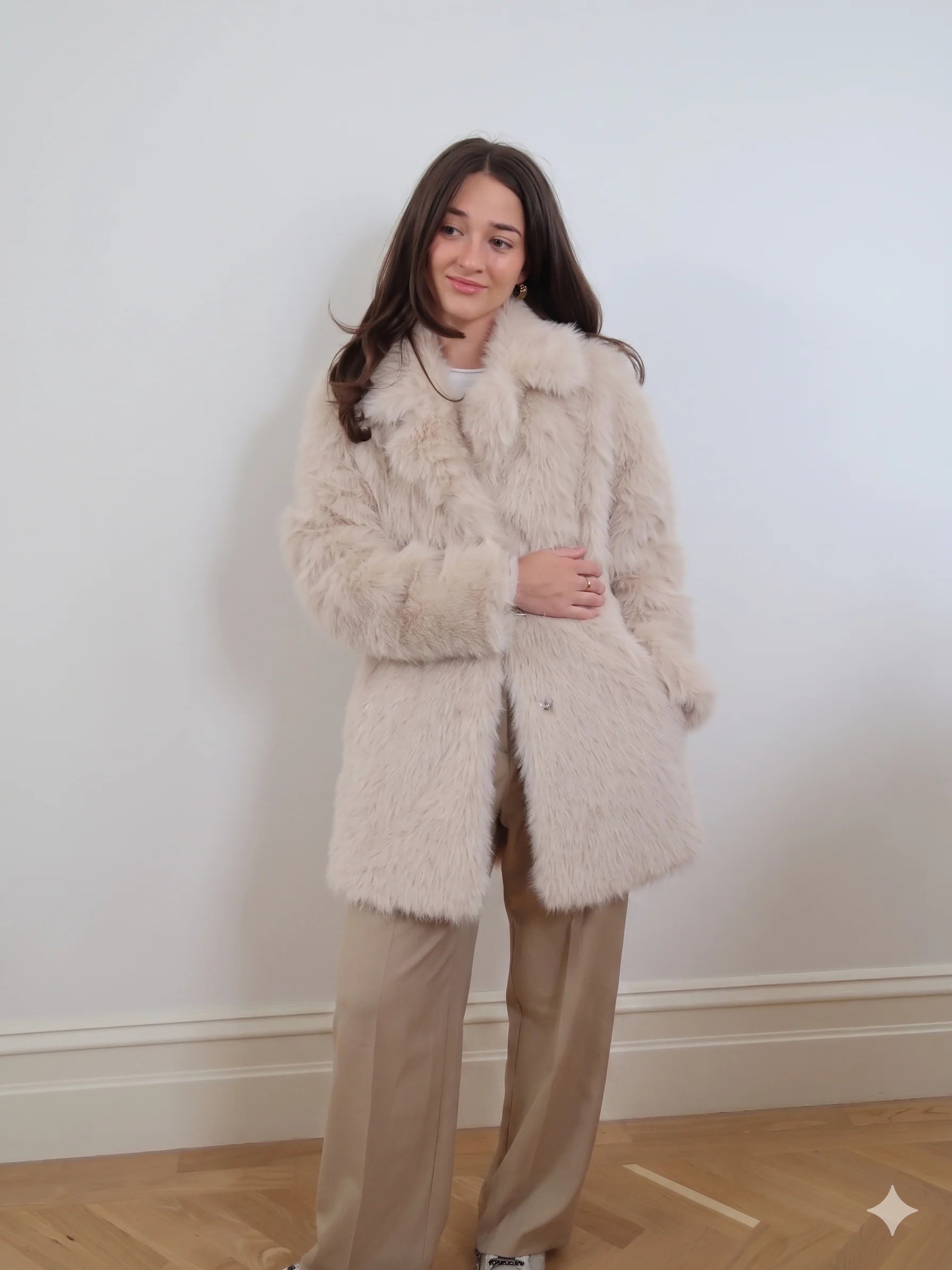 Beige long faux fur coat with soft plush texture, classic collar, and two-button closure in an elegant longline style.