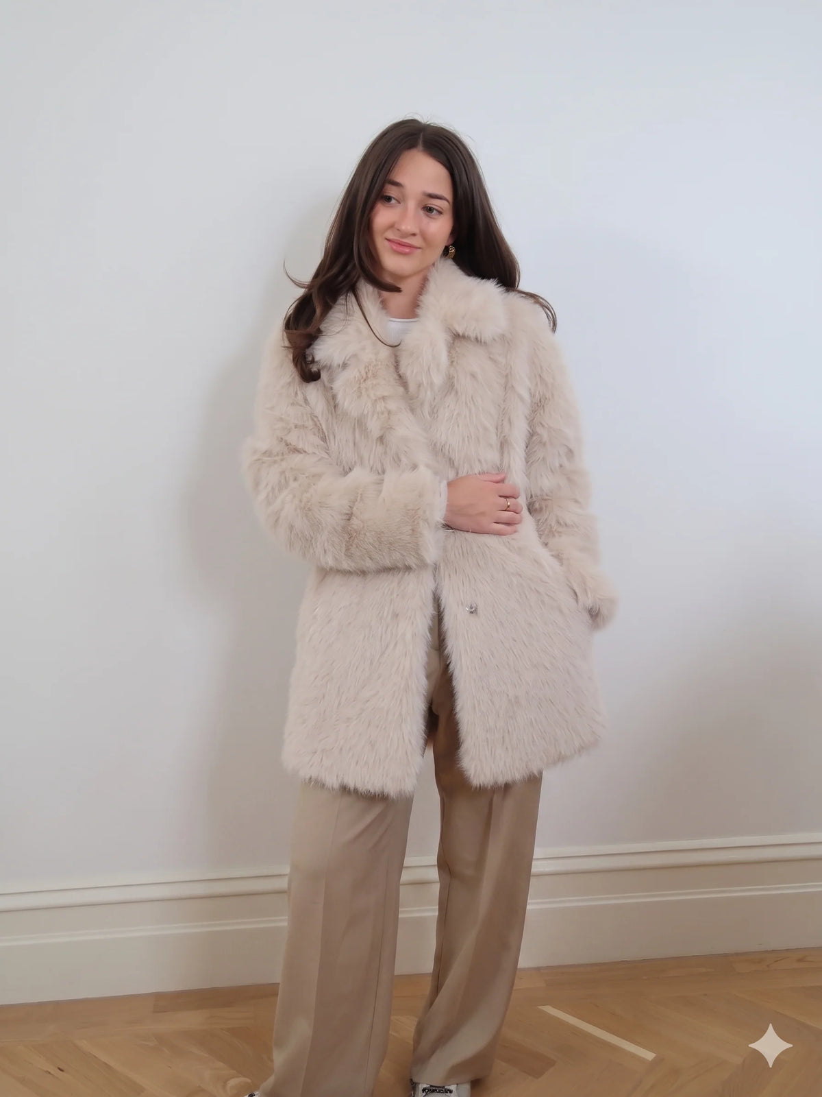 Beige long faux fur coat with soft plush texture, classic collar, and two-button closure in an elegant longline style.