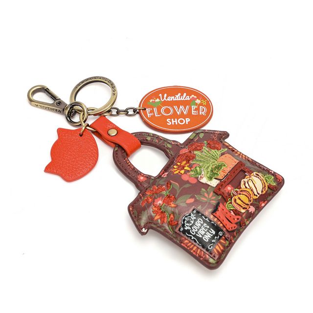 Vendula London Flower Shop Amber Edition Key Charm in printed and embossed vegan leather, featuring warm amber tones and floral artwork inspired by the Flower Shop collection. Includes a branded dog-clip and split ring for attaching to keys or a handbag.