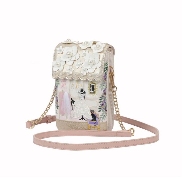 Vendula London vegan leather phone pouch featuring printed and embossed artwork, hand-stitched details, a front slip pocket, magnetic flap closure, secure zip fastening, two internal compartments, a back zipped pocket and a detachable flat shoulder strap.