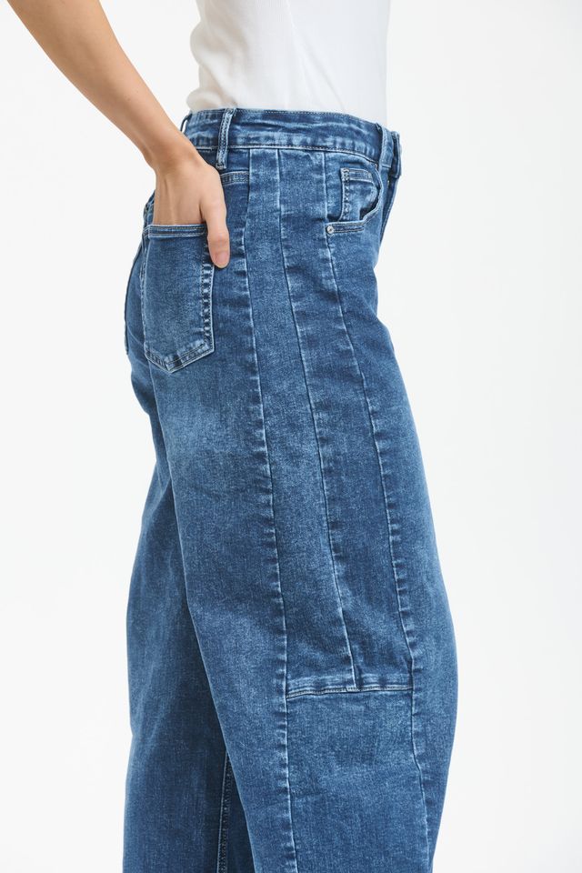 Blue denim barrel leg jeans with curved silhouette and tapered ankle