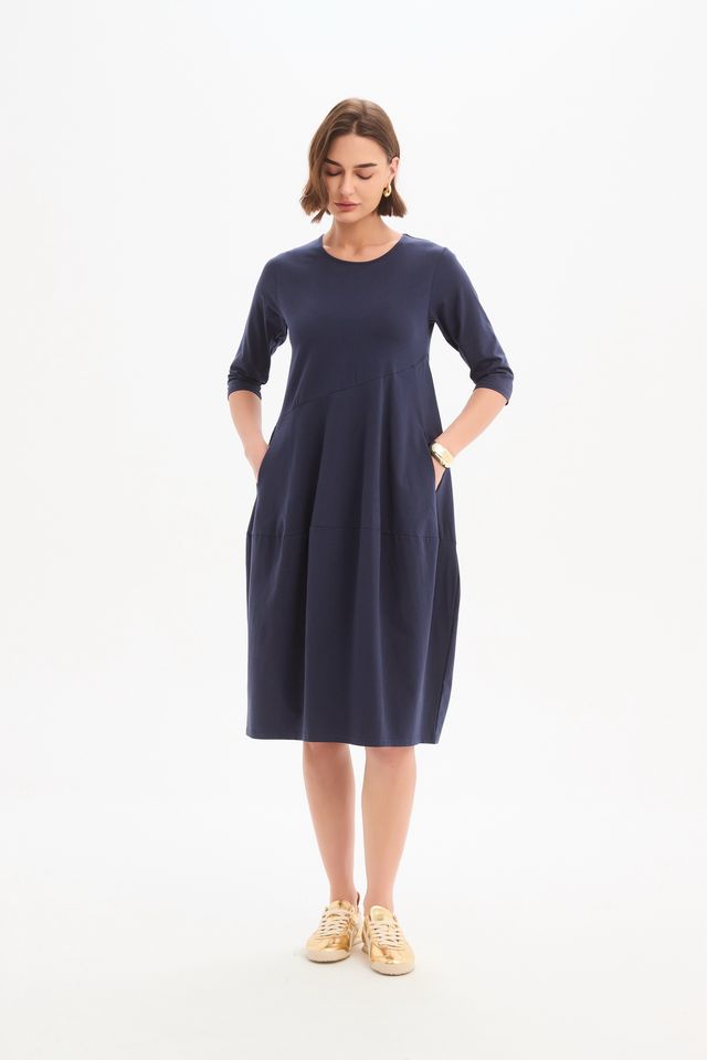 Tirelli Diagonal Seam Winter Dress in navy featuring a midi-length silhouette, diagonal seam detailing, rounded bubble hem, round neckline, and side pockets